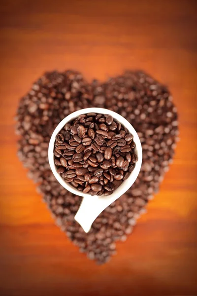 ハート型の豆のコーヒーカップのトップビュー — ストック写真