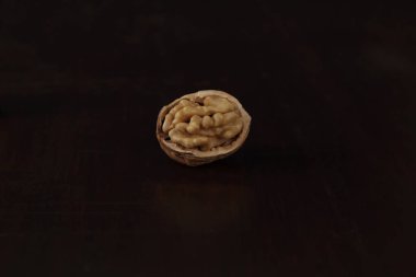 Yarım kahverengi ceviz kabuklu, ahşap arka planda izole edilmiş.