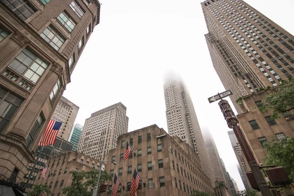 New York, États-Unis - 17 juin 2017 : Vue sur une rue du centre-ville de Manhattan. De hauts gratte-ciel s'élèvent vers le ciel par temps nuageux. Rues urbaines de New York . — Photo