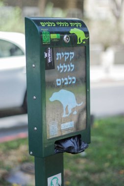 Tel Aviv, İsrail - 10 Mayıs 2017: Parktaki köpekler için İsrail 'de temizlik kuralları imzalanır. Plastik torba, temiz çevre.