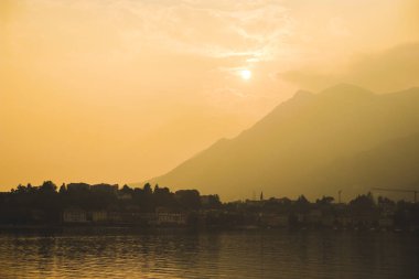 Kuzey İtalya, Lombardy bölgesindeki Bergamo Alplerinin eteklerinde yer alan küçük bir göl komünü olan Lecco 'nun gezinti alanında güzel bir günbatımı. Yakın görüş: Como Gölü, Bergamo, Milan, Iseobea Gölü