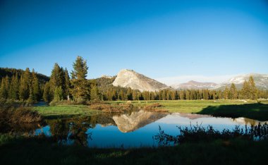 Tuolumne Meadows ve Lembert Dome 'un sakin sulardaki yansımaları, Yosemite Ulusal Parkı, Kaliforniya, Usa