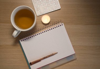 defter ve kupa ahşap masada.