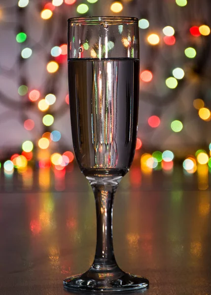 wineglass with sparkling wine on garland background