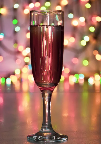 wineglass with sparkling wine on garland background