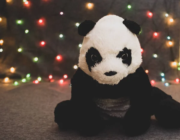 Çelenk arka planında küçük bir panda oyuncağı