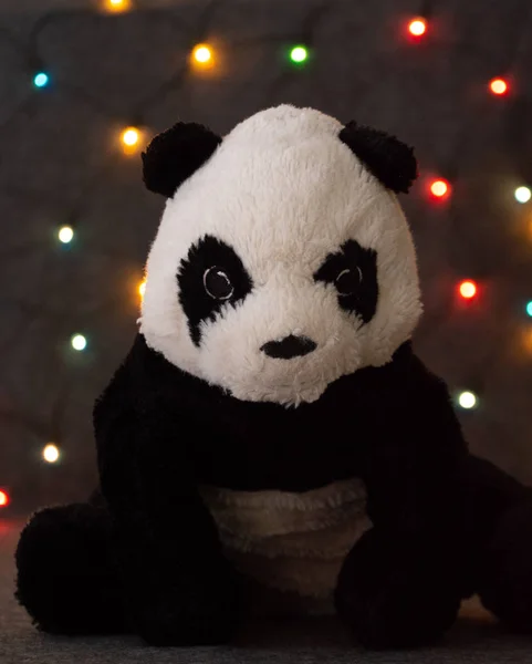 Çelenk arka planında küçük bir panda oyuncağı