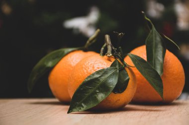 Noel ağacı arka planında portakal rengi mandalina 