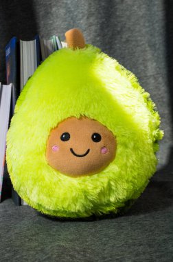 Gri arkaplanda pelüş bir avokado