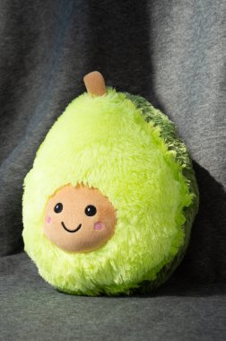 Gri arkaplanda pelüş bir avokado