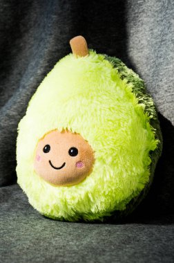 Gri arkaplanda pelüş bir avokado