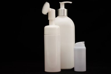 Siyah zemin üzerinde beyaz plastik kozmetik şişe