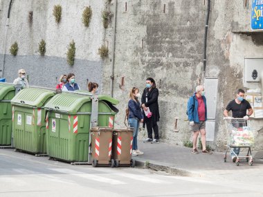 Süpermarkete girmek için kuyruğa girecekler. Hepsi de Ceneviz 'in ikinci safhasında kendilerini Cavid 19 virüsünden korumak için maskeyle.