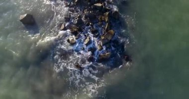 Deniz dalgaları kayalara çarpıyor.