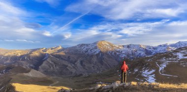 Genç adam köyün dağlık çevresi bakan 