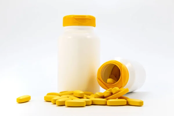 Potten van medicijnen onder de pillen liggend op een witte achtergrond — Stockfoto