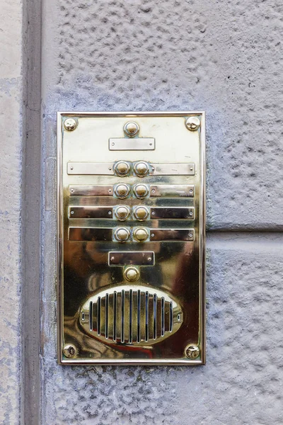 An old-fashioned doorphone on a stone wall Stock Photo