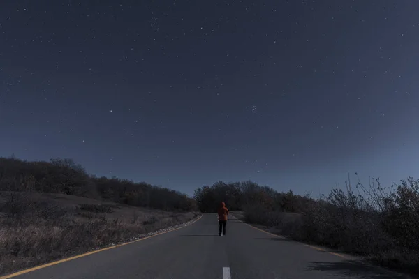 El hombre en la carretera en una noche de luna — Foto de Stock