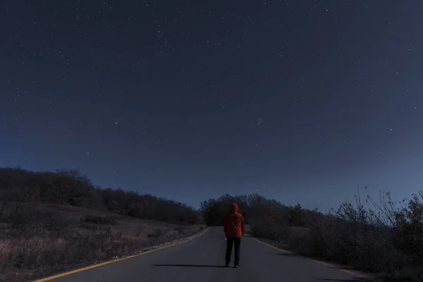 El hombre en la carretera en una noche de luna — Foto de Stock
