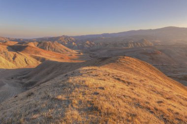 Fotoğrafçı gün batımında dağlarda çekim yapmaya hazırlanıyor.