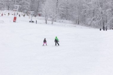 Eğitmen bir çocuğa kayak yapmayı öğretir.