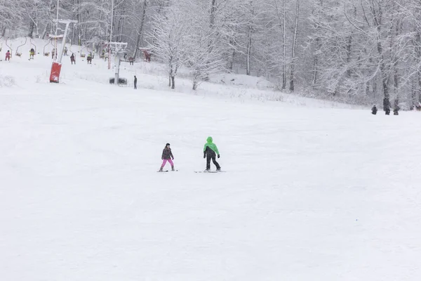 Un instructeur apprend à un enfant à skier — Photo