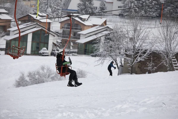 Esquiadores suben un teleférico a la ladera de una montaña — Foto de Stock
