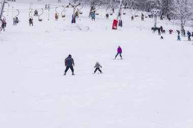 Eğitmen bir çocuğa kayak yapmayı öğretir.