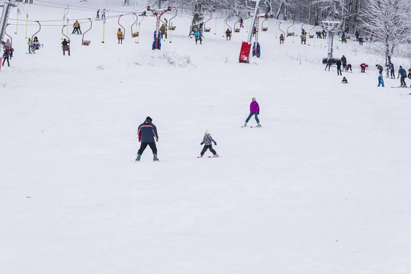 Un instructeur apprend à un enfant à skier — Photo