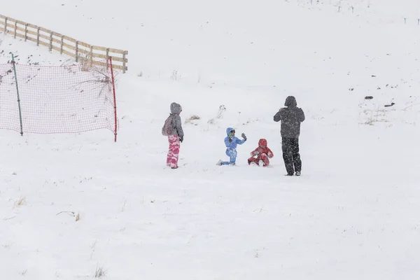 Familia tomando fotos y jugando en la nieve —  Fotos de Stock