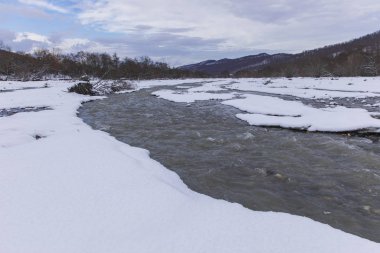 Nehir kışın bir dağ geçidinden geçer.