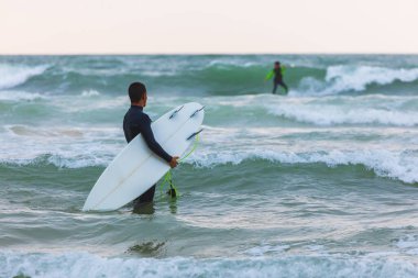 Herzliya, Israel - March 05, 2020: Surfer rides the waves of the Mediterranean Sea