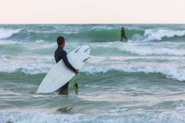 Herzliya, Israel - March 05, 2020: Surfer rides the waves of the Mediterranean Sea