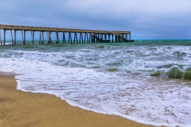 Kıyıdaki iskele fırtınalı havada denize açılıyor.