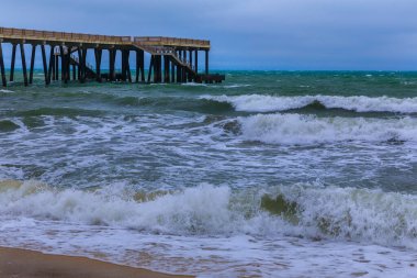 Kıyıdaki iskele fırtınalı havada denize açılıyor.