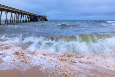 Kıyıdaki iskele fırtınalı havada denize açılıyor.