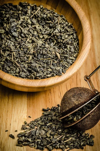 Green tea, dried leaves with filter, on wooden background — Stock Photo, Image