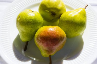 Beyaz arka planda parlak armutlar, meyveler ve sağlıklı yiyecekler.