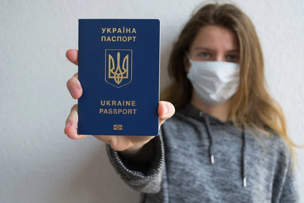 Genç bir kız, Ukrayna vatandaşı. Koruyucu maskeli, pasaportlu..