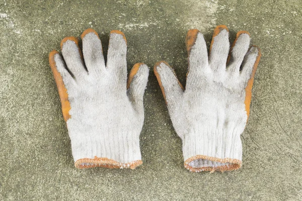 Dirty and old glove on concrete floor