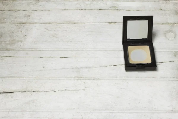 Used Compact pressed powder on white wooden background