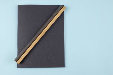 Siyah defter ve kalem mavi zemin üzerine.