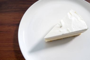 Beyaz çanak üzerinde beyaz pasta bir parça. 