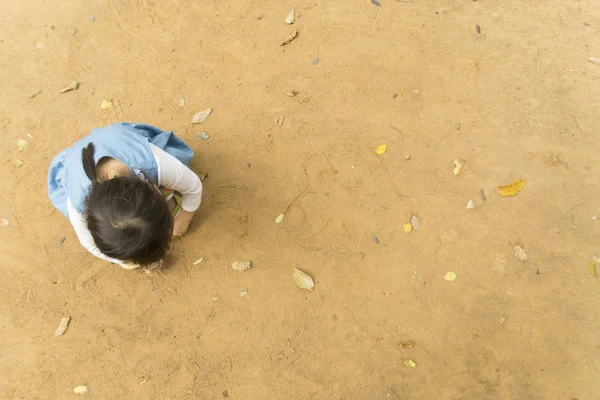 Ein kleines Mädchen zeichnet Bilder auf den Boden. — Stockfoto