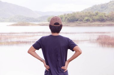 Gezgin adam güzel göl önünde ayakta.