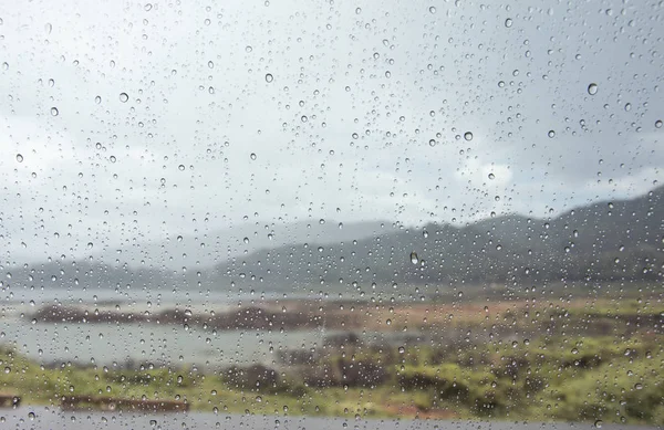 Gotas de agua de lluvia en la ventana del coche con vista a la montaña . —  Fotos de Stock
