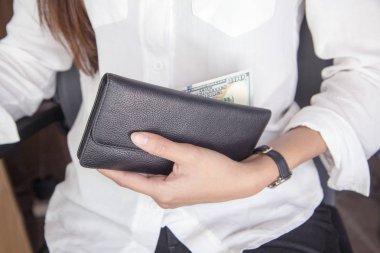 Siyah deri çanta 100 dolarlık banknot kadın el ile