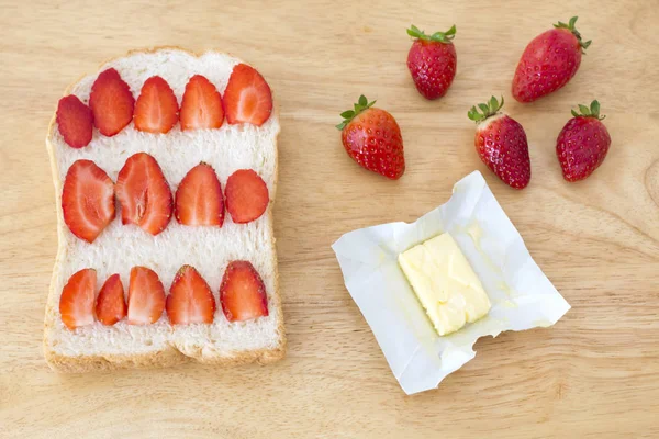 Whole wheat bread and pieces of strawberry and fresh butter — Stock Photo, Image