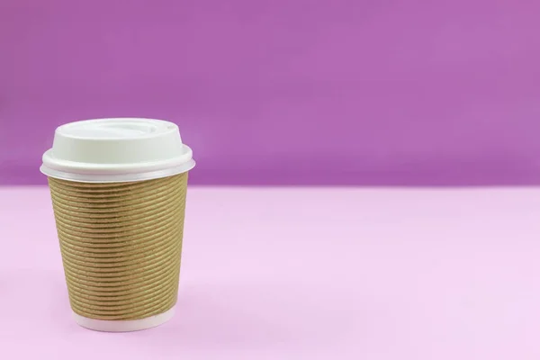 Take out paper coffee cup on purple and pink background.