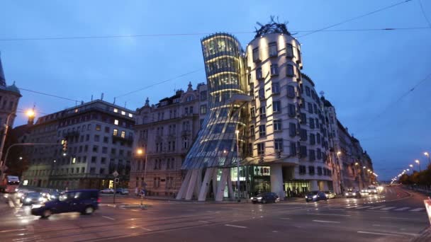 Modern red tram is passing Dancing House in Prague — Stockvideo